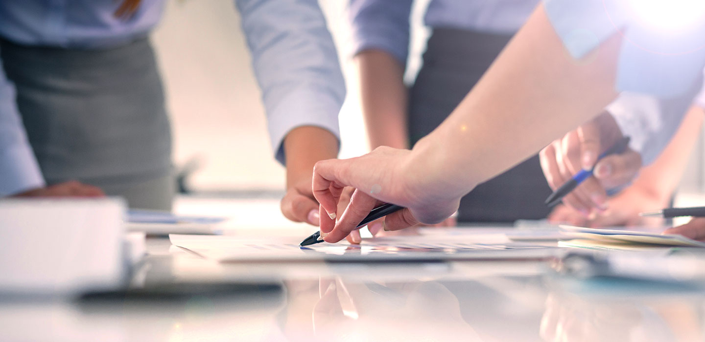 A closeup of people interacting with a document on a table