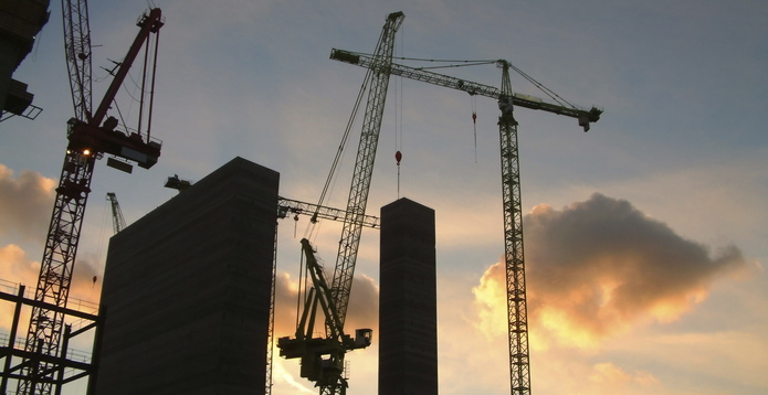 Construction cranes at sunset