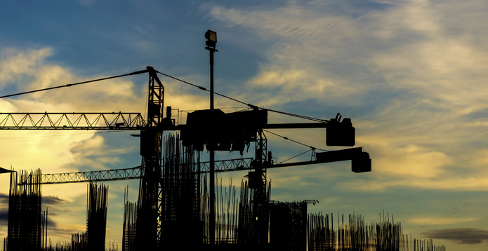 Construction site with cranes on silhouette background