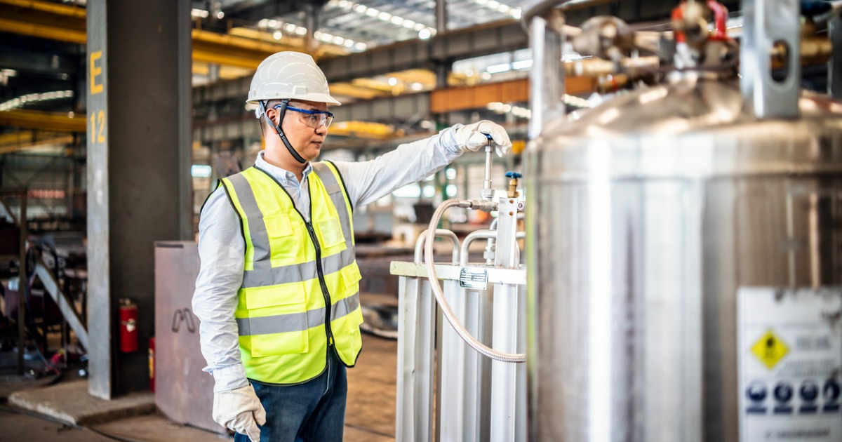 Asian worker operating a gas tank in a factory