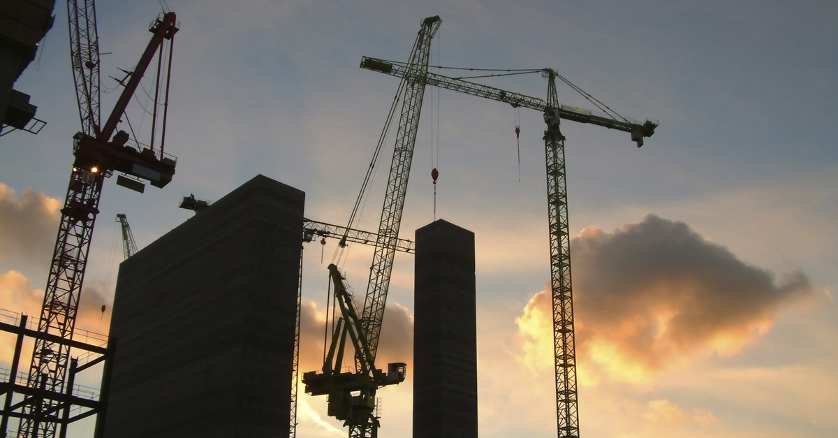 Construction cranes at sunset