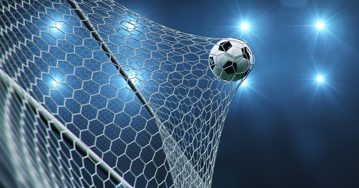 A football flying into a goal net against a blue background